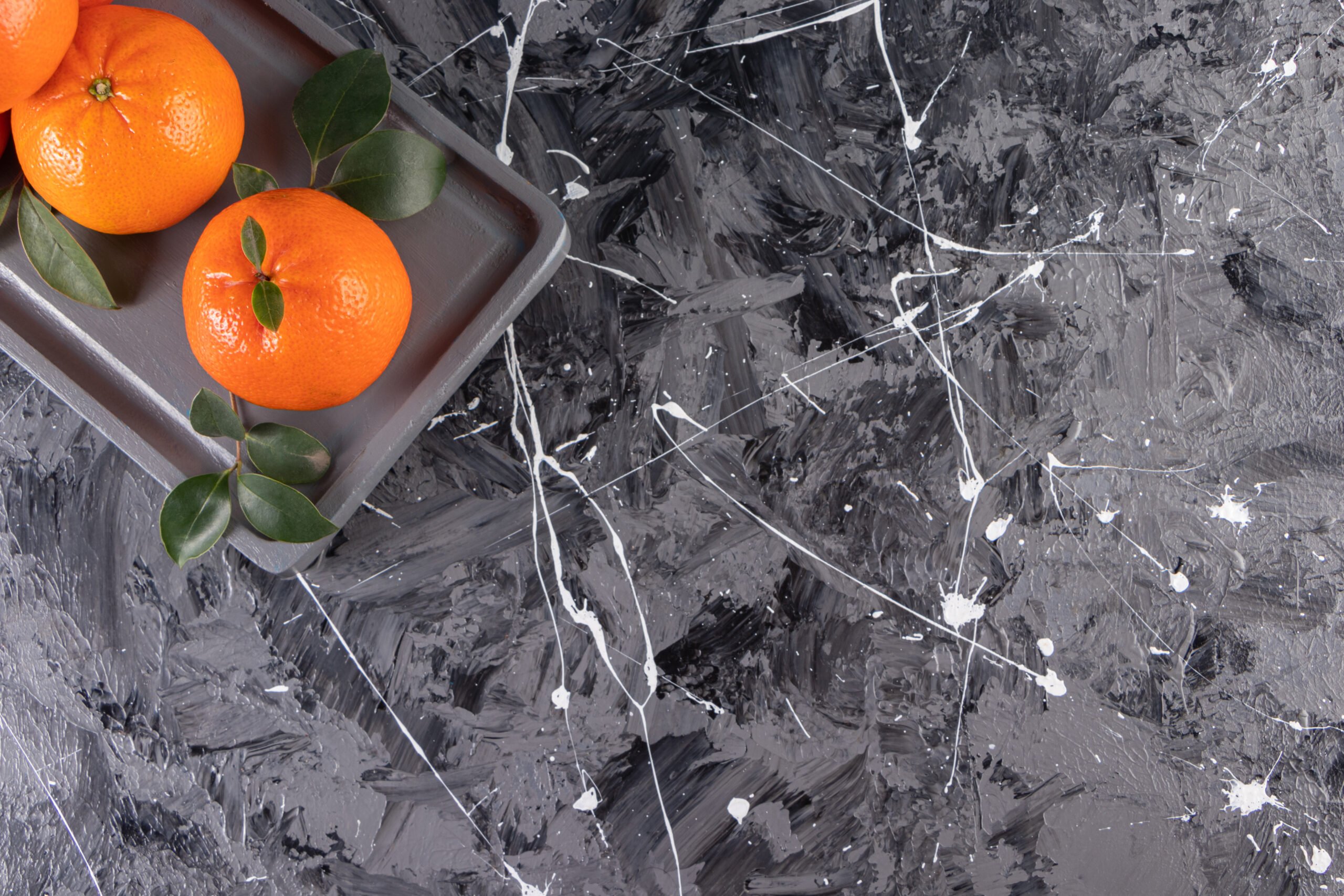 Dark Plate Of Juicy Whole Oranges On Background Marble Countertop