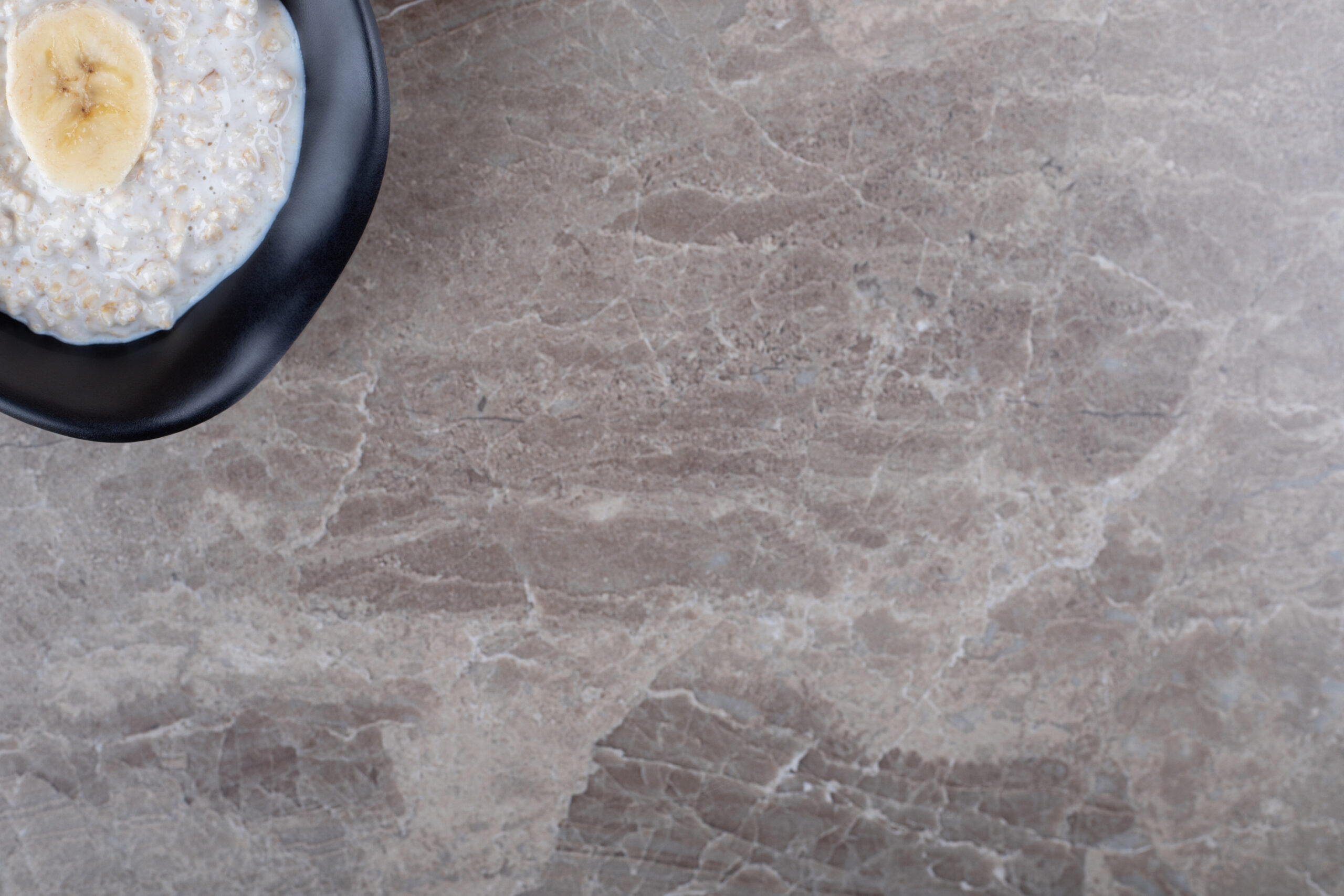 Ripe Sliced Banana On A Bowl Of Porridge On The Background Marble Countertop