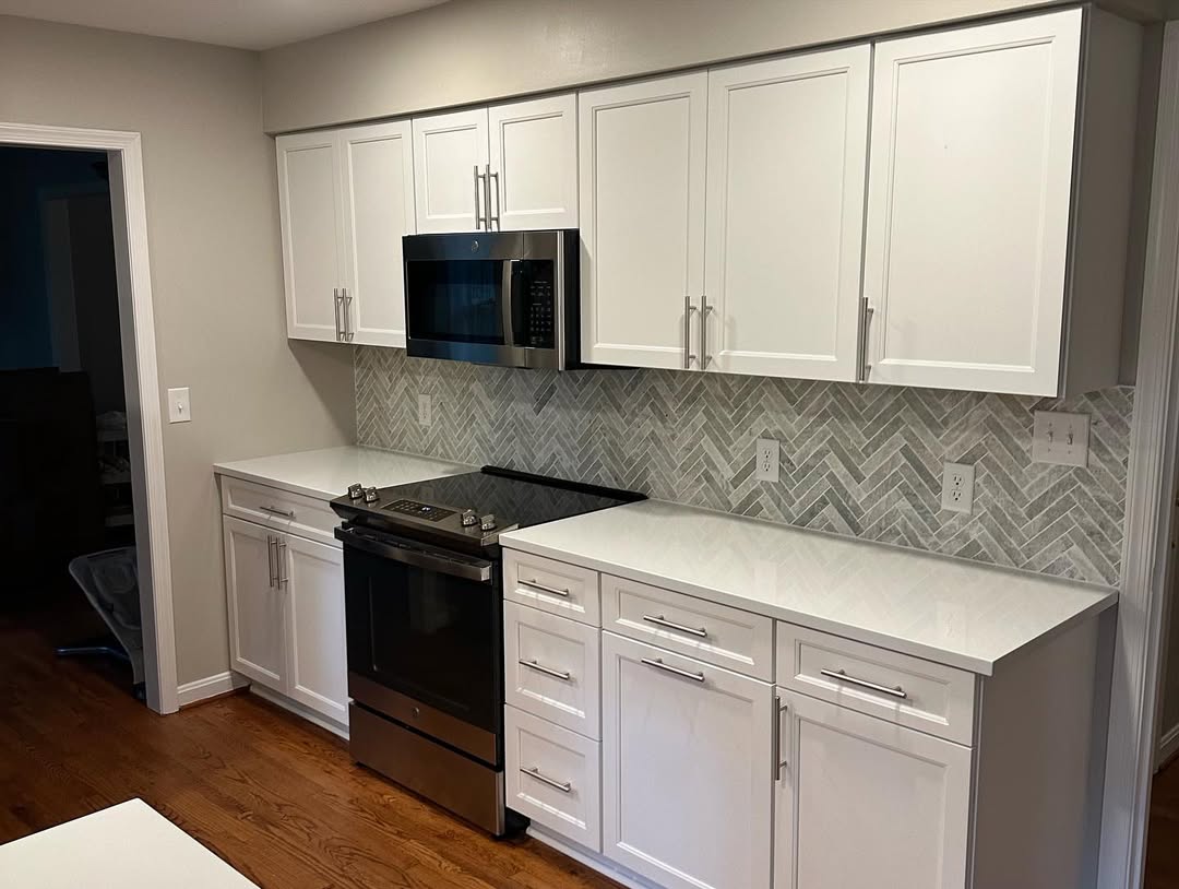 White shaker kitchen with quartz countertops and herringbone tile backsplash installed by Prime Countertops in the DMV area